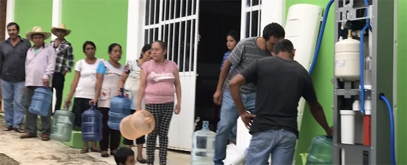 Habitantes de una comunidad llenando garrafones en una planta potabilizadora Villagepump